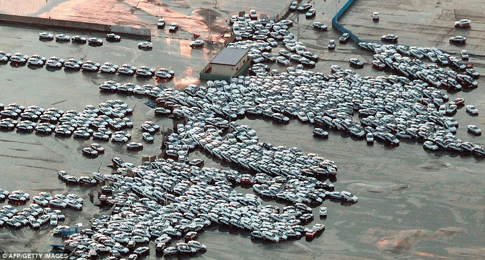Pile-up: New cars ready to be shipped are stacked on top of each other after the water gushed through Hitachinaka city in Ibaraki prefecture 