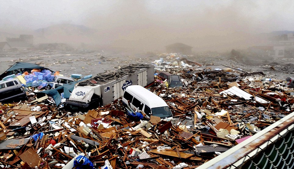 Debris: An eerie mist moves over the debris of destroyed homes and cars caught in the raging tsunami waters