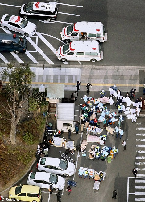 Injured people are attended to by emergency personnel after an earthquake in downtown Tokyo Japan March 11, 2011.