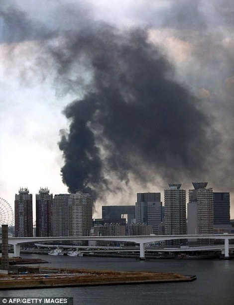 Black smoke raises from a building in Tokyo's waterfront Daiba in Tokyo on March 11, 2011. A massive 8.8-magnitude earthquake shook Japan, 